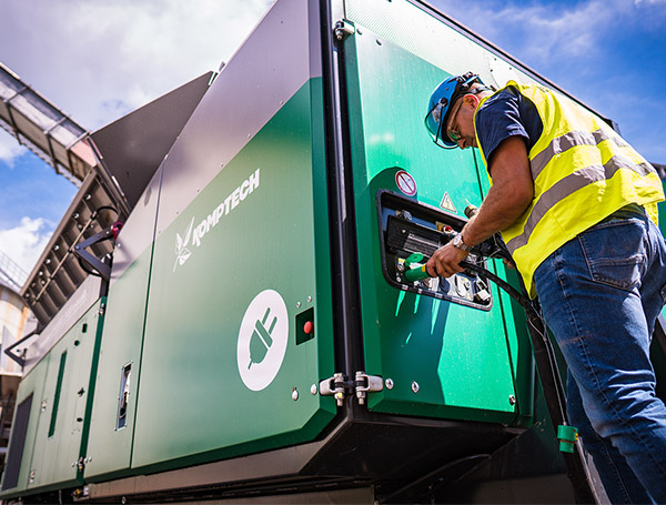 Service technician fueling a komptech machine, while wearing a safety equipment.